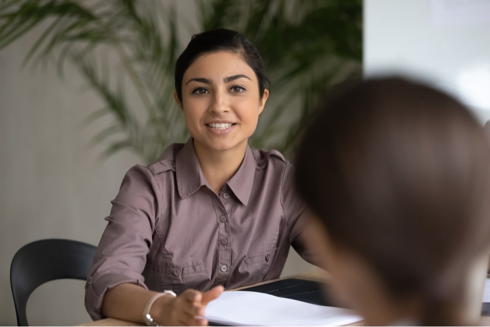 happy young indian ethnic businesswoman talking about finance business project