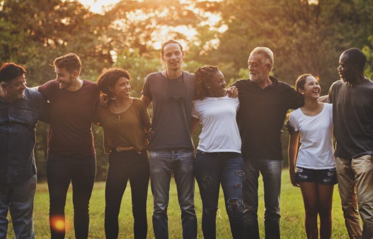 Cheerful diverse people huddling in the park