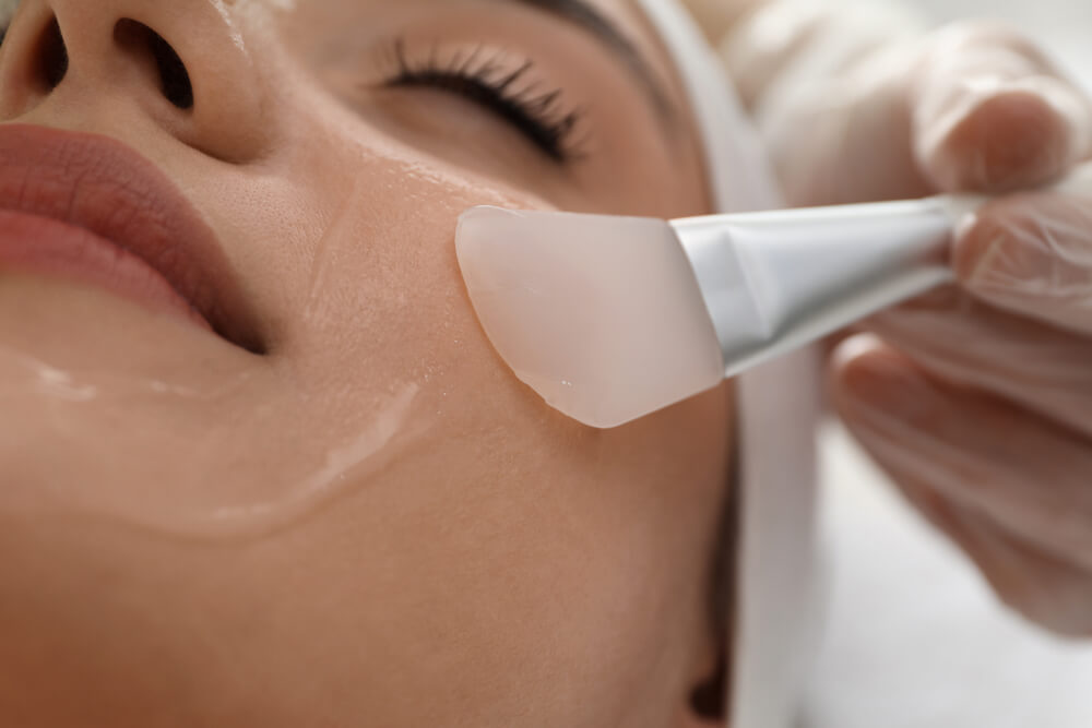 Young woman during face peeling procedure