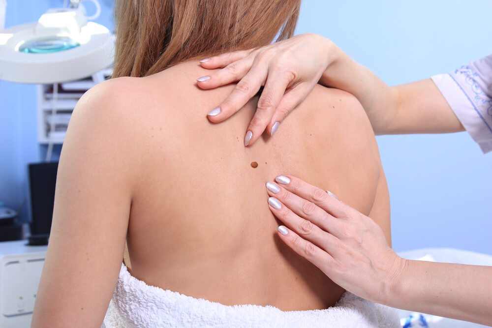 Doctor inspecting woman patient skin