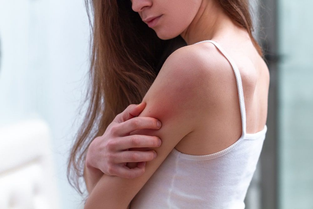 Young woman suffering from itching on her skin