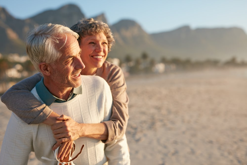 happy mature man carrying his beautiful wife