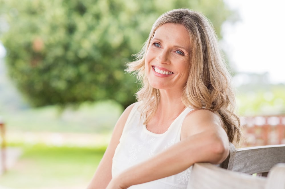 Happy blonde mature woman sitting outdoor