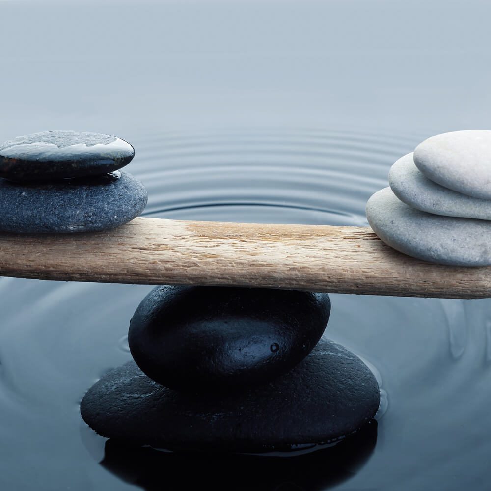 Carefully balanced black and white stones in water