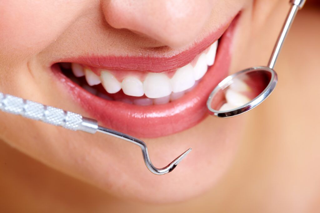 Beautiful woman smile with dental tools