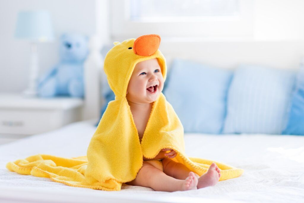 infant sitting up in duck towel