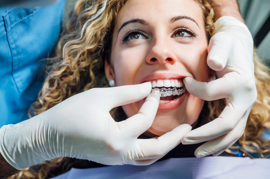 woman having her invisalign alingers checked by a dentist