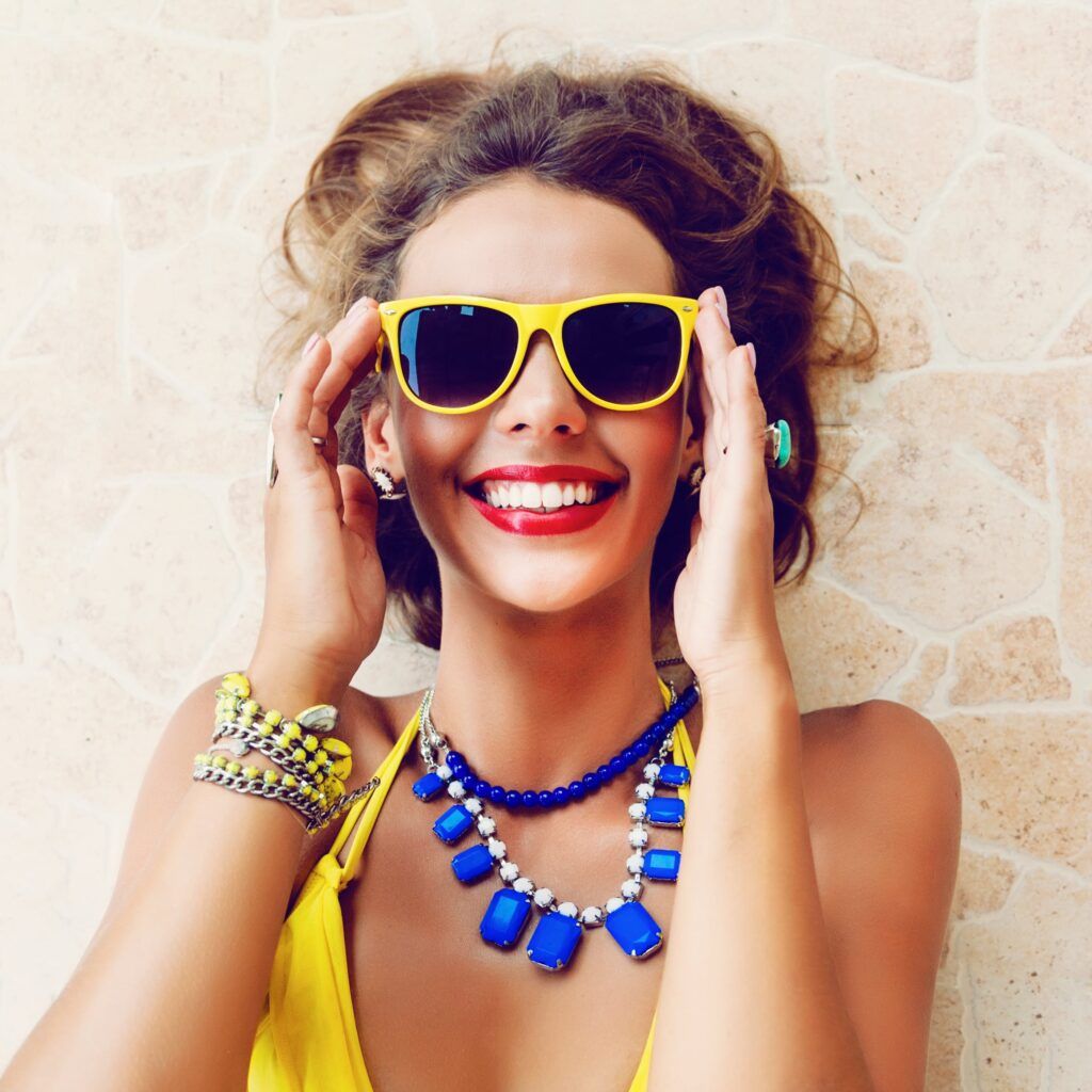 pretty woman with yellow sunglasses smiling
