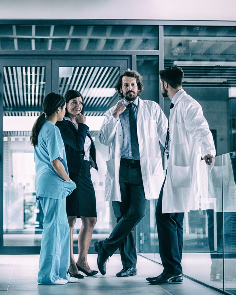 Businesswoman interacting with doctors in hospital