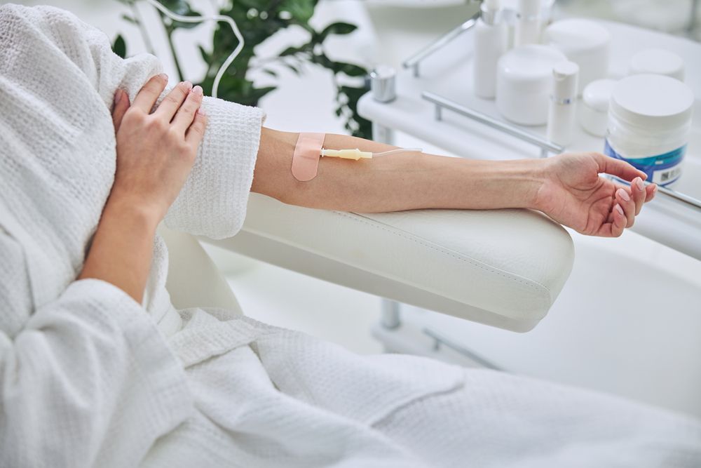 Young female in white bathrobe during medical procedure in beauty clinic