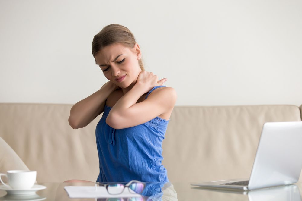 Tired woman feeling neck pain, massaging tense muscles, suffering from chronic shoulder back ache