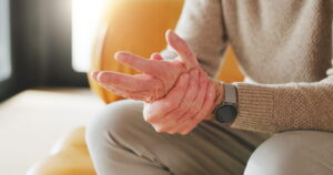Senior person, massage and hand pain at house from arthritis, carpal tunnel and joint stiffness.