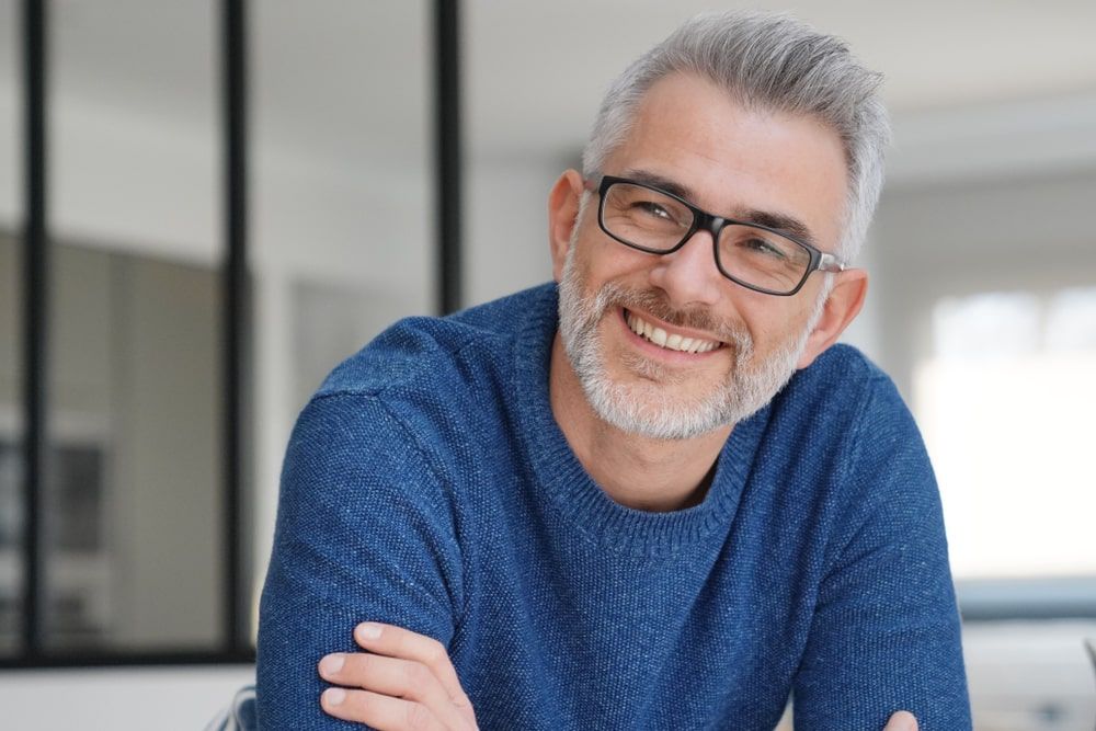 smiling man with grey hair and glasses