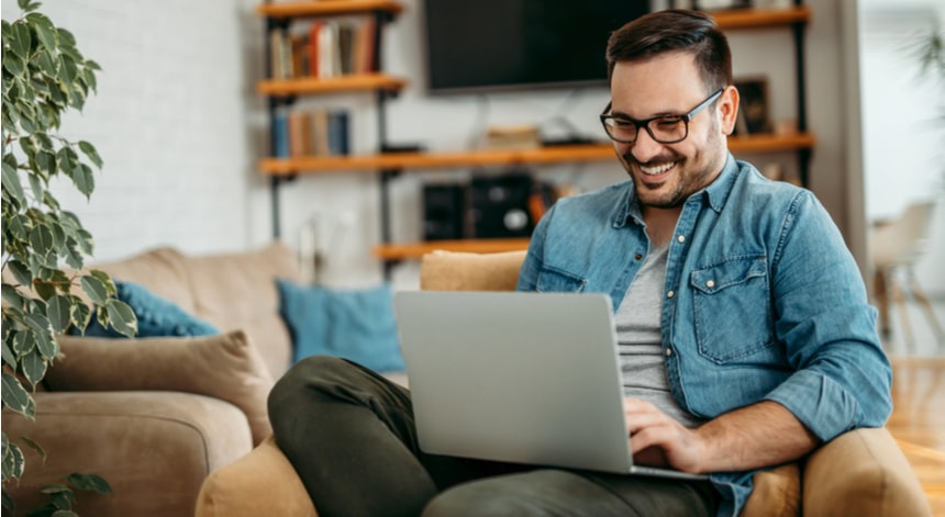 Handsome man relaxing at home, using laptop