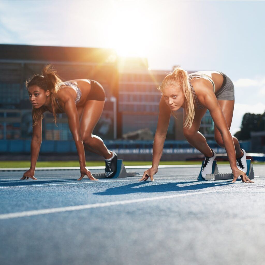 Two female athletes at starting position ready to start a race