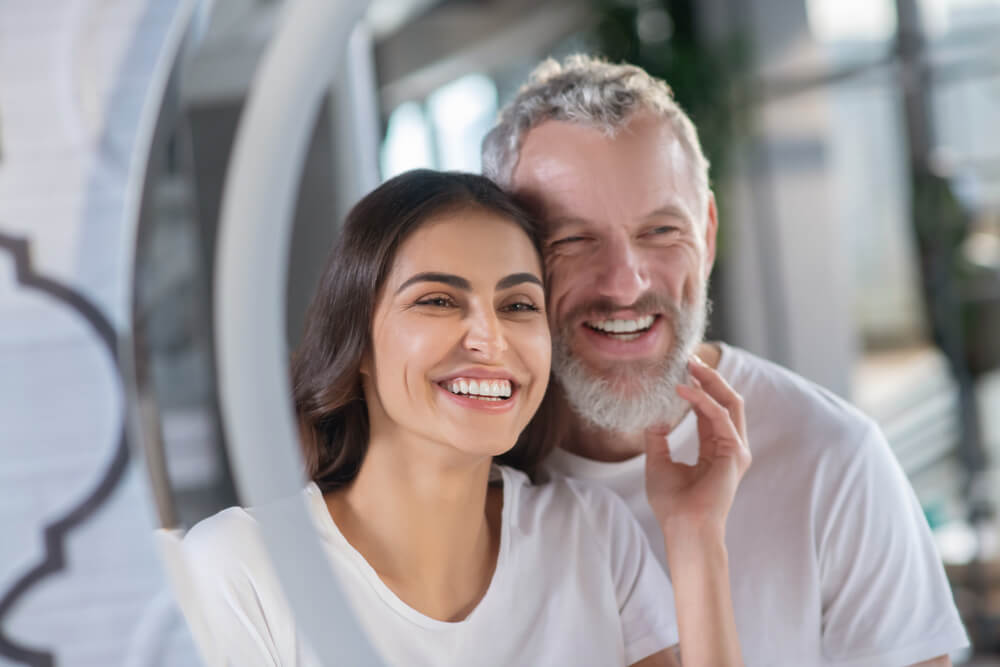 Smiling man and woman looking at the mirror