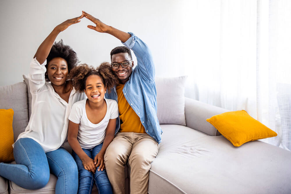 Happy family mother father and kids with roof at home