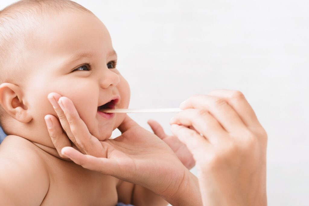 Cute little baby smiling while dentist checking his teeth