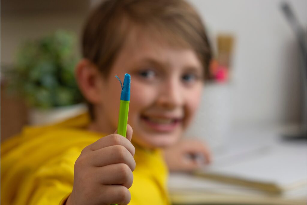 Little boy showing his blue crayon