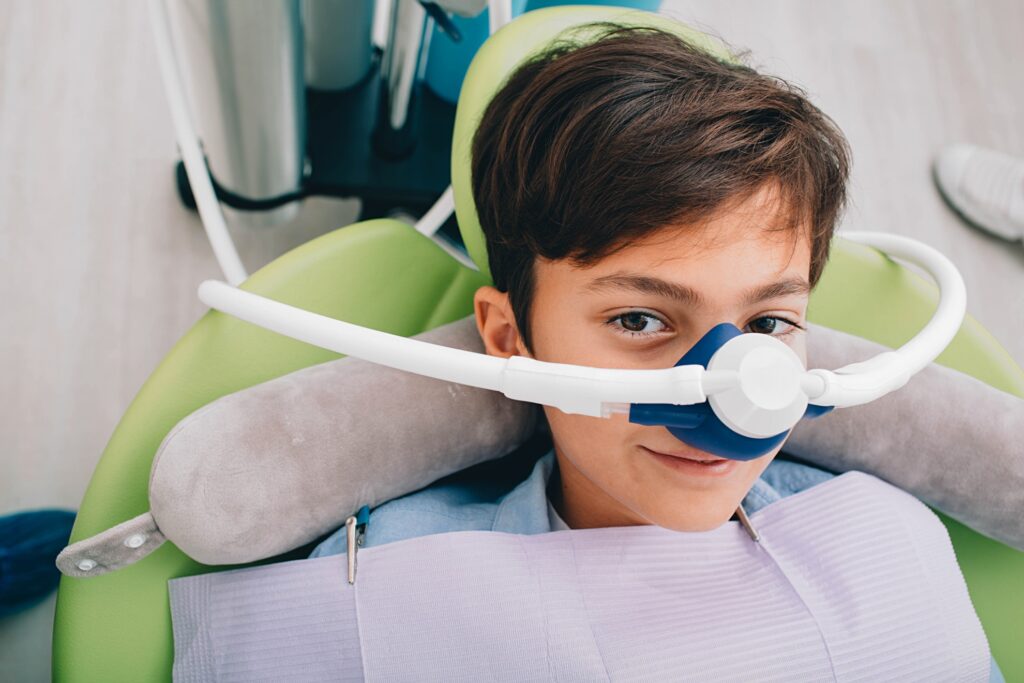 Little boy getting Inhalation Sedation while teeth treatment at dental clinic