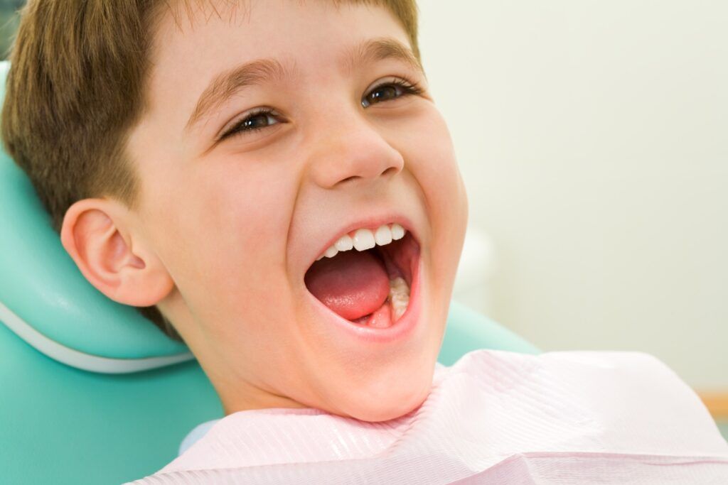 Photo of youngster with his mouth wide open during checkup at the dentist