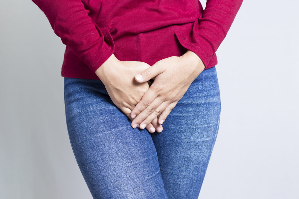 Woman with Hands Holding her Crotch Isolated in a White Background