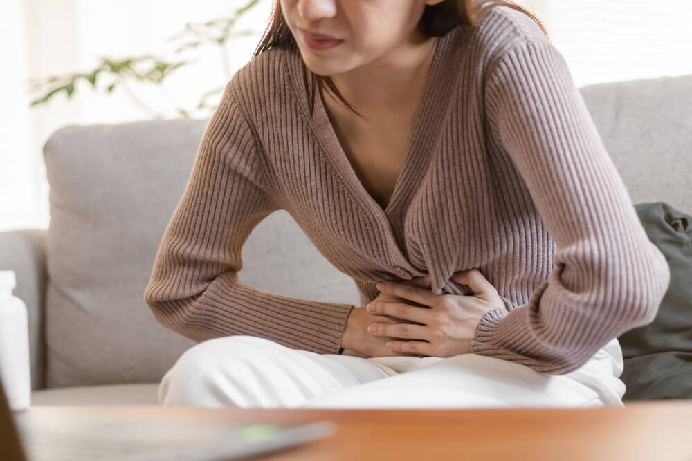 Flatulence young asian woman, girl hand in stomach ache, suffer from food poisoning