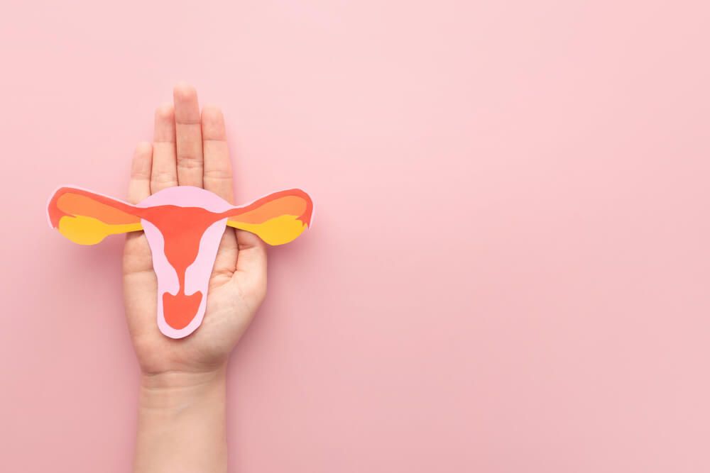 Woman hand holding uterus shape made frome paper