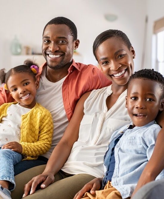 happy mature couple with son and daughter relaxing on sofa at home