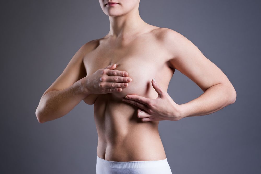 Woman holding her breast thinking about getting a Breast Revision