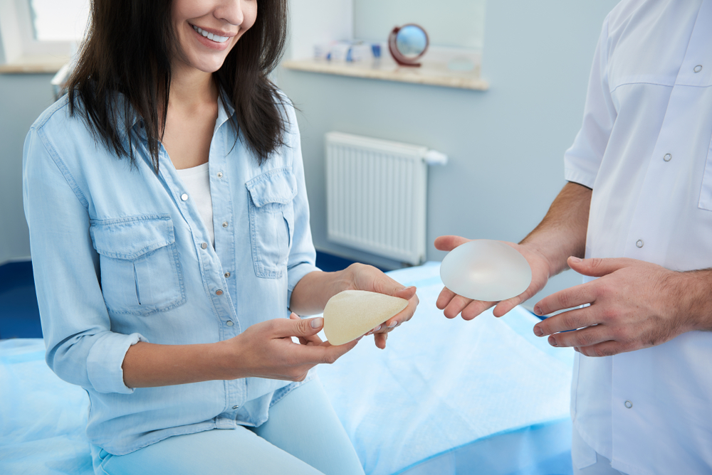 A woman discussing Breast Augmentation while looking at implants