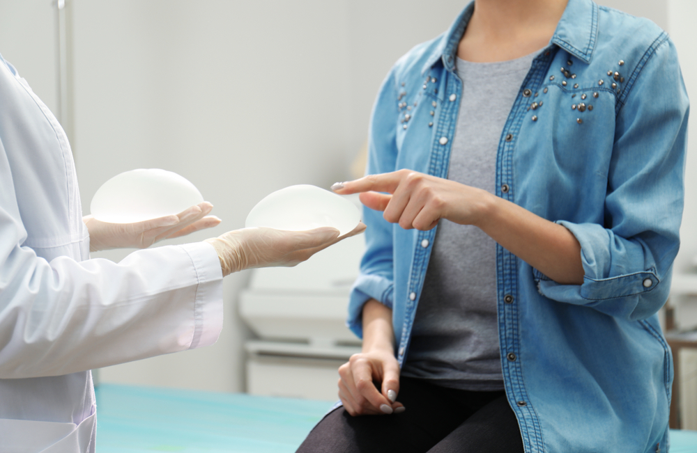 Doctor showing silicone implants for breast augmentation