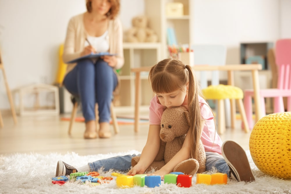 Cute little girl during play therapy at psychologist's office