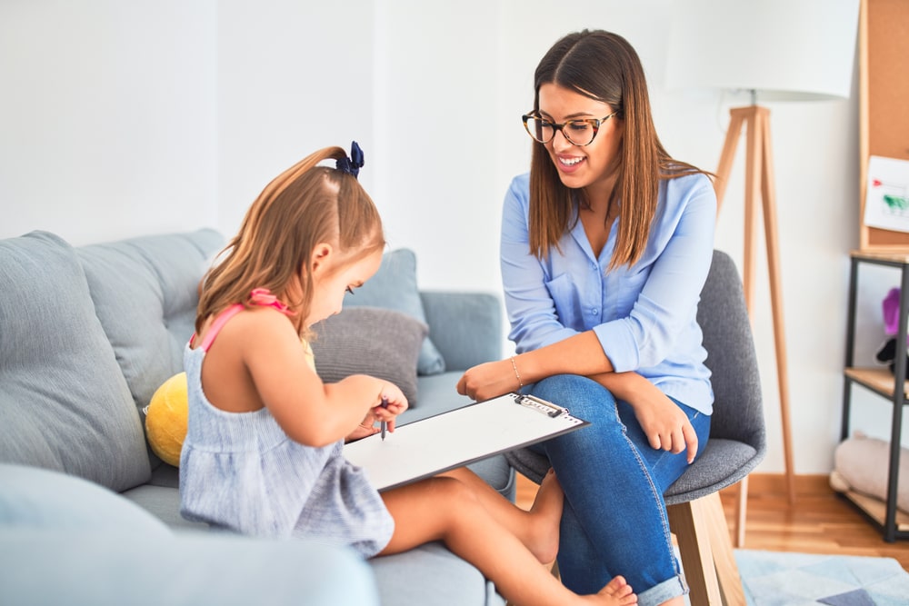 Young therapist woman speaking and treating child