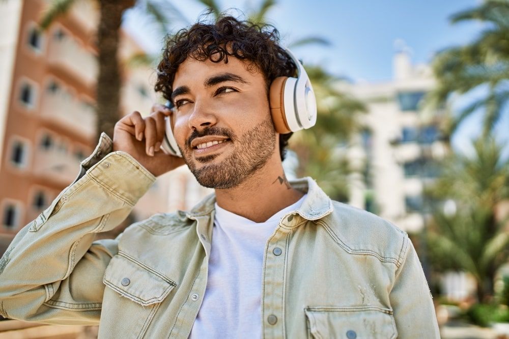 Handsome man with smiling on a sunny day wearing headphones
