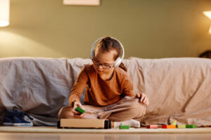 Autistic Child Sitting on the couch with sensory headphones. Autism therapy on the rise