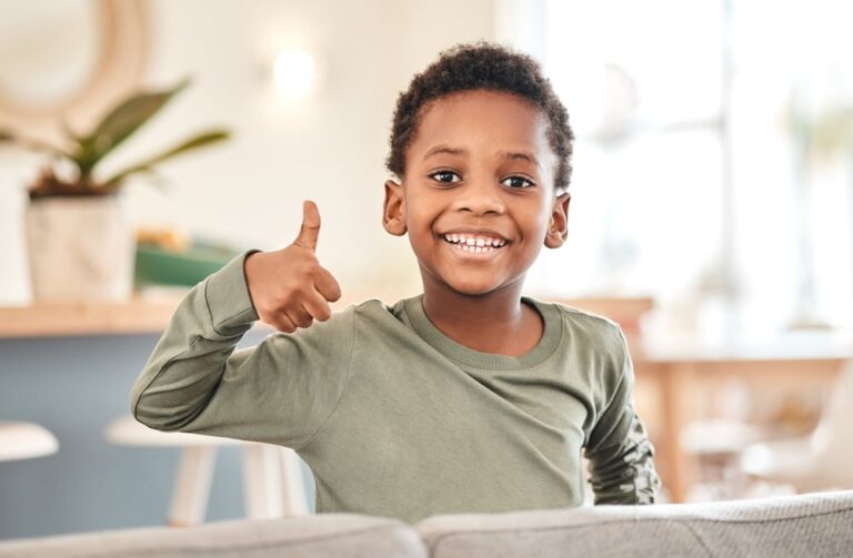 Adorable little boy showing thumbs up