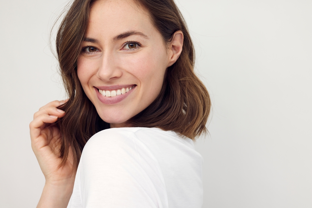 Woman smiling at the camera after receiving Periodontal Treatment