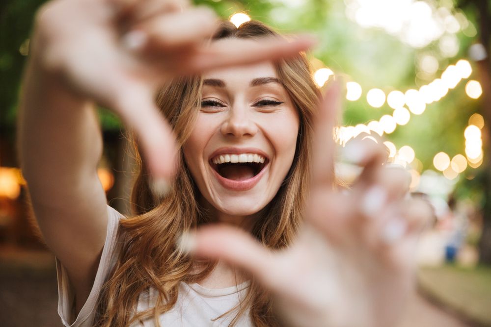 Woman smiling in the camera after receiving Teeth Whitening 