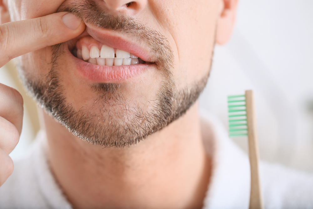 A man looking at his teeth to see if he needs Tooth Extractions