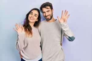 couple smiling hands up