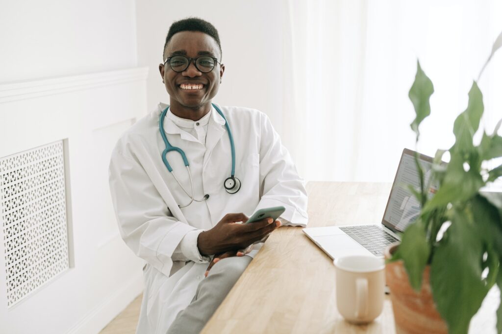 African American doctor with glasses using phone