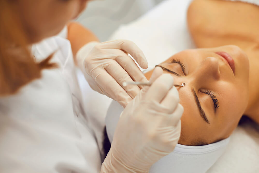 High angle of cosmetician using blackhead and whitehead