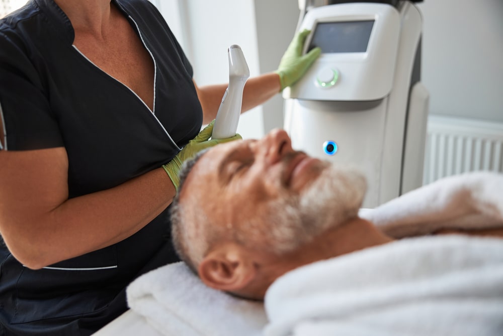 Professional beautician starting a machine for photofacial treatment