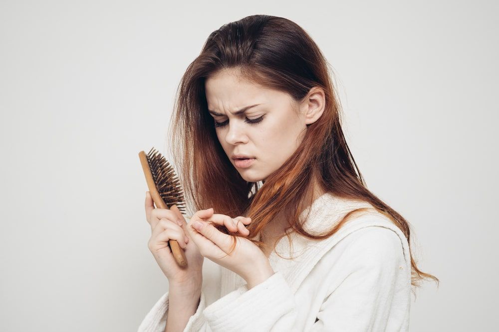 Woman with a comb in her hands problem hair