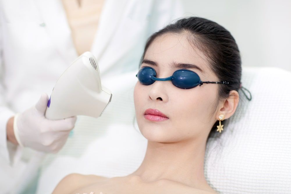 Beautician Giving Laser Epilation Treatment To Young Woman's Face