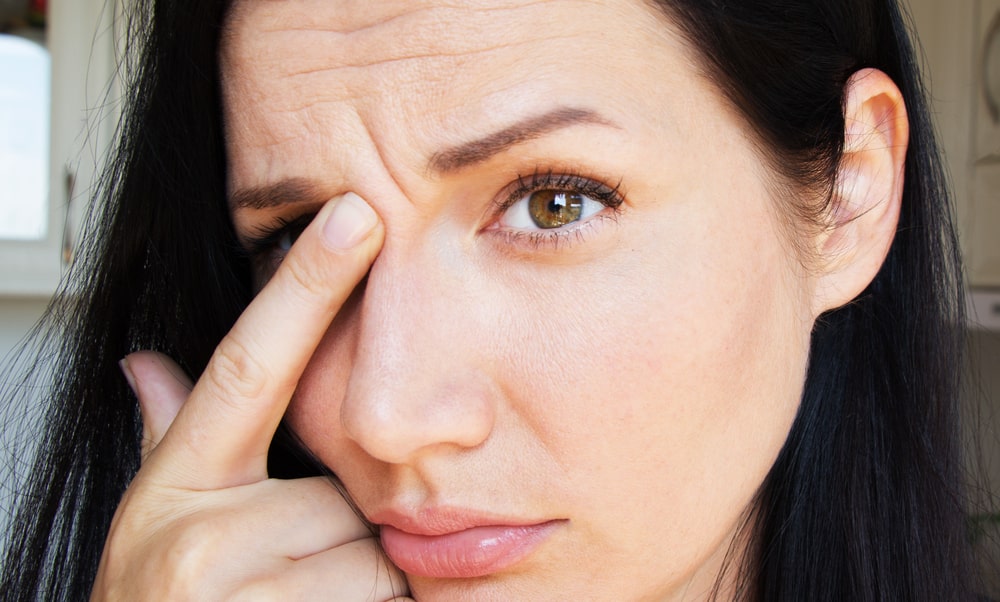 young woman with mimic wrinkles on her forehead