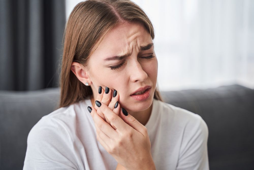 Awful Toothache. Frustrated Young Women Suffering From Toothache While Sitting