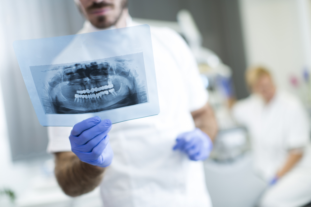 Dentist Analyzing X-ray Of Teeth