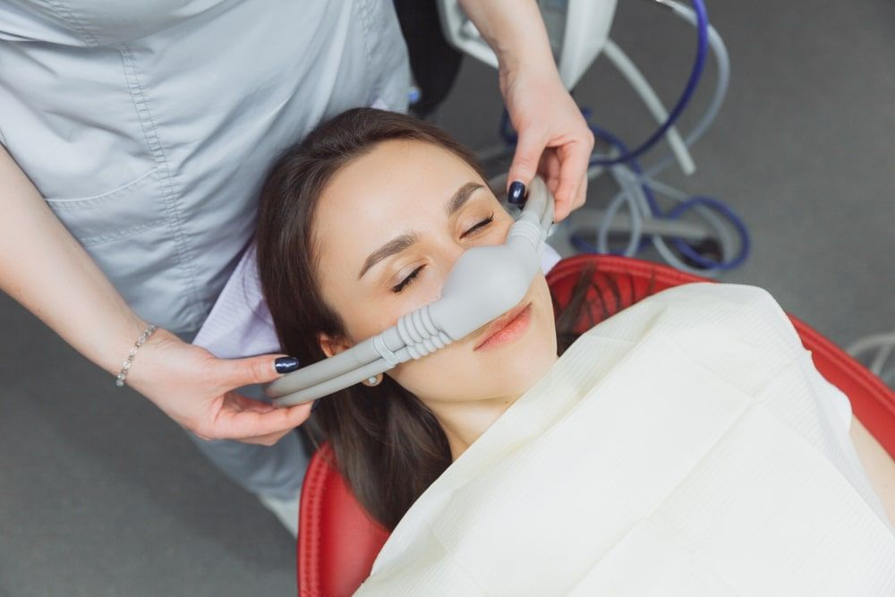 dentist puts inhalation sedative mask
